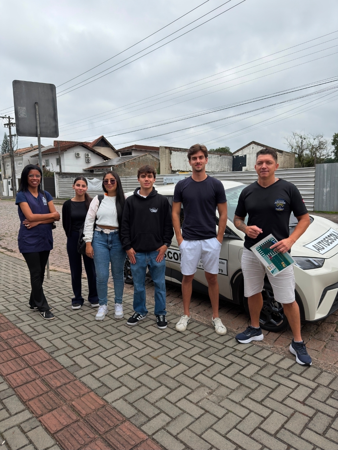 Alunos aprovados ao lado do carro de aulas em Joinville